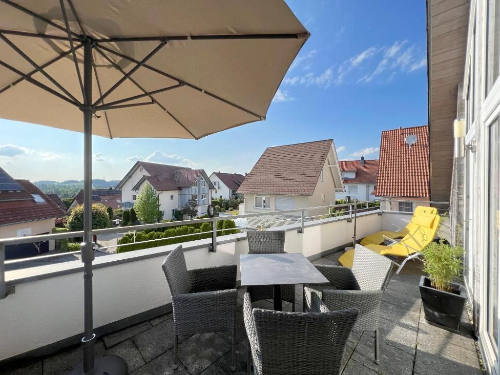 Dachterrasse mit Tisch, vier Sesseln, Sonnenschirm und Sonnenliege